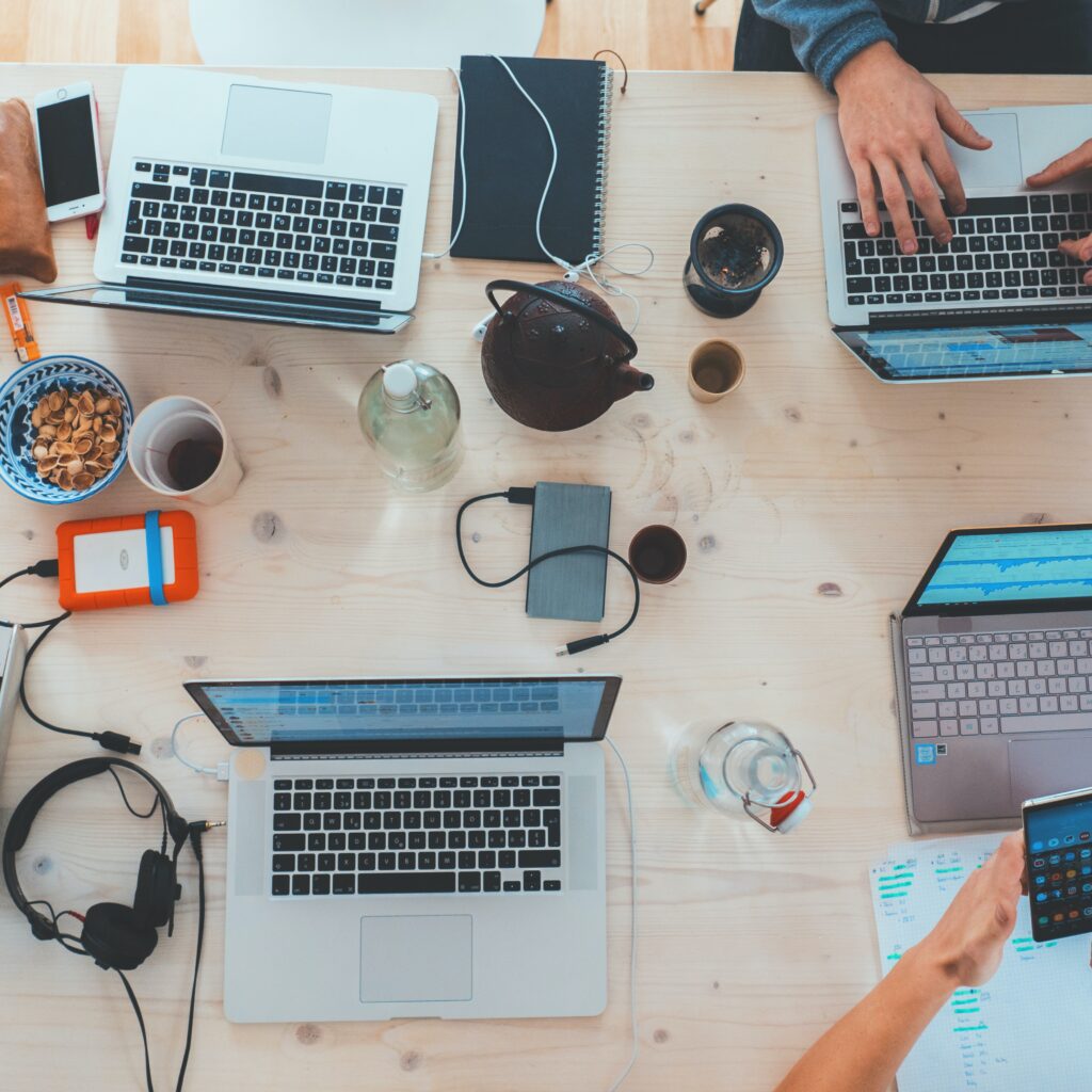 Laptops on the desk and people work on them